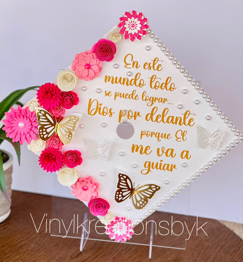 Custom graduation cap topper with pink flowers, butterflies, and Spanish inspirational quote